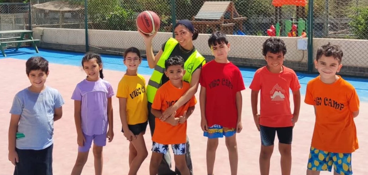 Campers with their coach on the basketball court