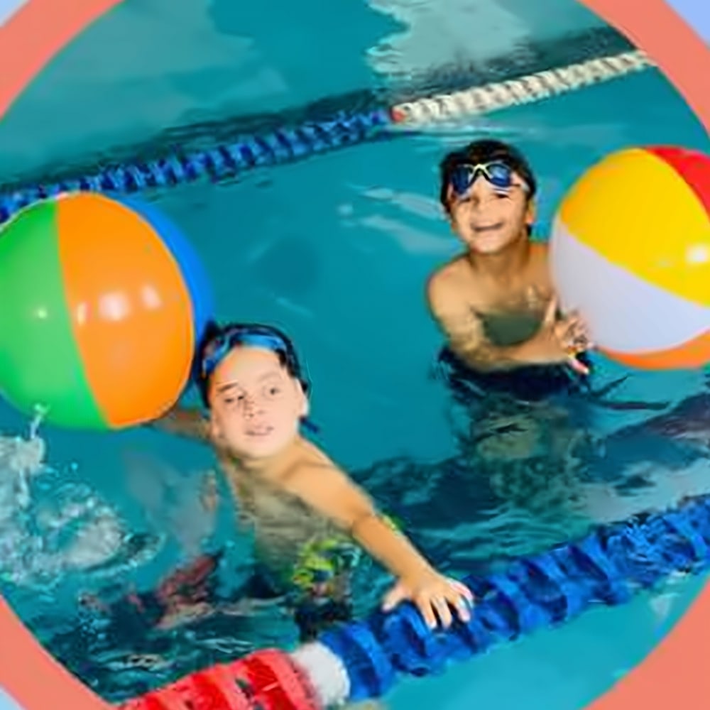 Boys playing with beach balls in the pool