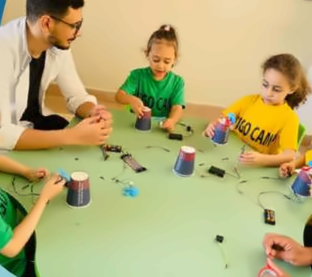Young campers wiring simple circuits with their coach